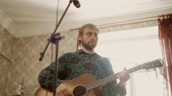 Adult Musician Playing Guitar in Home Studio