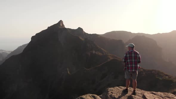Man Hiker Standing on the Edge of a Cliff in the Mountains of Madeira Island, Portugal alt