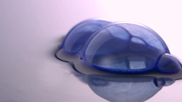 Blue bubbles on water surface popping, Slow Motion alt