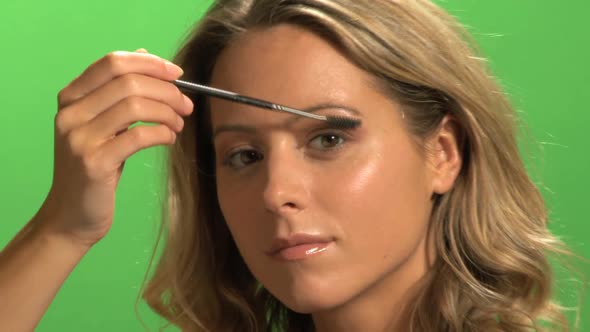 CU OF A YOUNG WOMAN APPLYING MASCARA alt