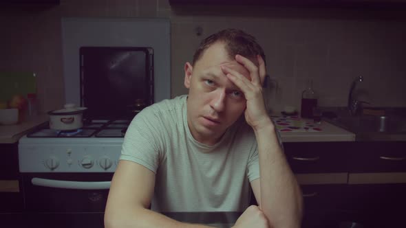 Portrait of a man sitting in the kitchen in the evening, camera movement alt