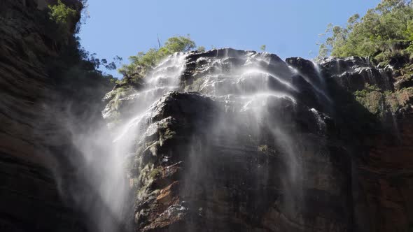 Low angle view of wentworth falls in the blue mountains, Australia with the wind blowing the water c alt