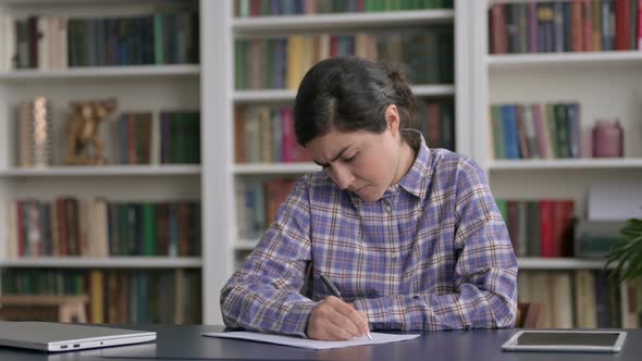 Indian Woman having Disappointment while Writing on Paper alt