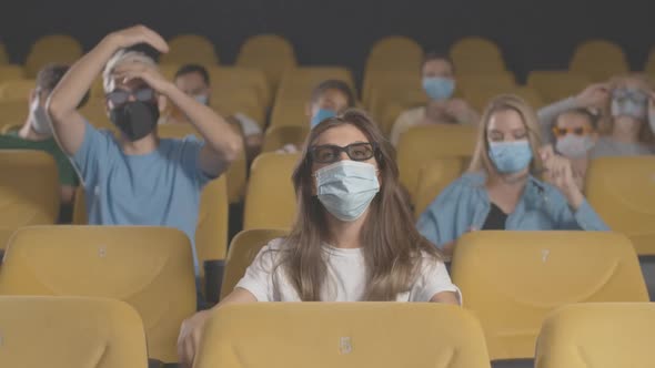 People in Face Masks Watching 3d Film in Cinema on Coronavirus Quarantine. Portrait of Men and Women alt