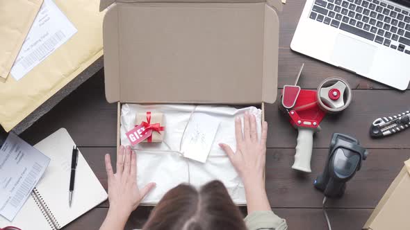 Top View of Female Online Store Business Owner Packing Ecommerce Shipping Box alt