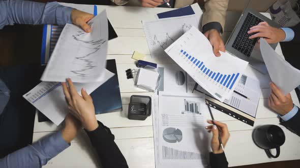 Top View Male and Female Hands of Colleagues Analyzing Financial Reports in Office. Business Team alt