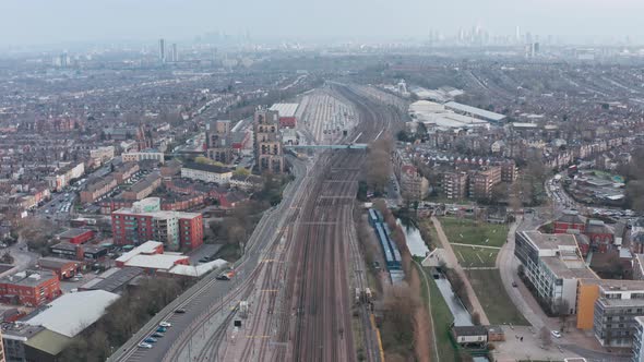 Drone shot over dense train tracks heading into London alt