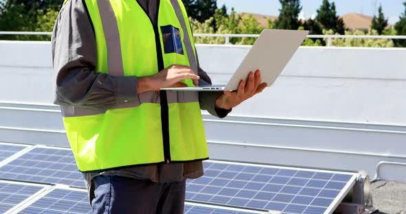 Male worker using laptop at solar station 4k alt