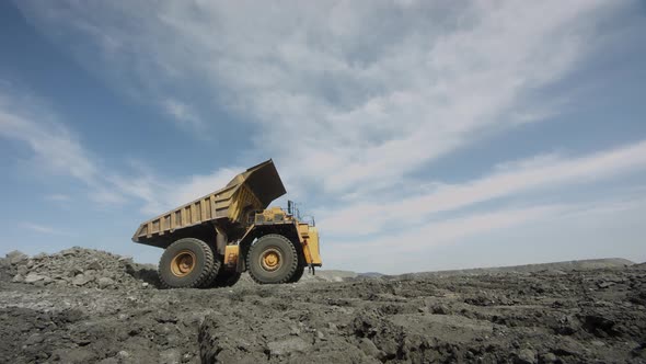Multiton Dump Truck Folds Its Body and Leaves After Unloading Waste Rock