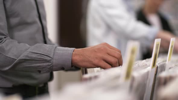Unrecognizable Multiethnic Customers Browsing through Vinyls in Record Shop alt