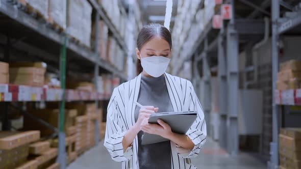 Asian woman business owner wear face mask using digital tablet checking stock