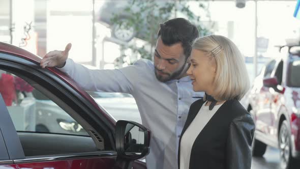 Happy Couple Choosing New Automobile at the Dealership