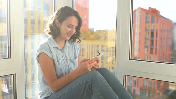 Positive Young Woman Using Smartphone for Video Call with the Friend alt