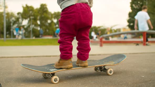 Legs of Funny Baby Standing on a Skate