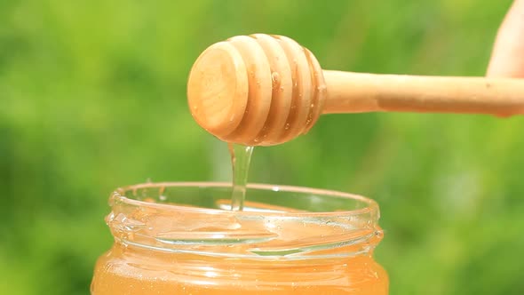 Glass Jar With Honey and a Stick 