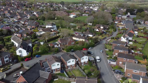 Aerial drone reveal shoting backwards over rural countryside houses, England alt