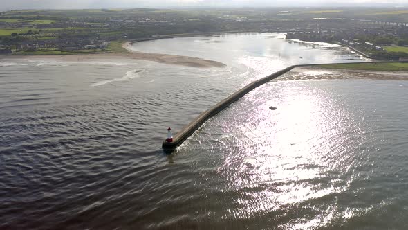 A Lighthouse and Breakwater at the Mouth of a Harbour in the UK alt