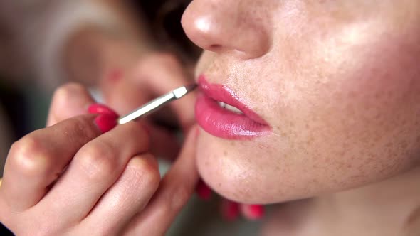 Hands of Professional Makeup Artist Applying Lipstick on Model's Lips Working in Beauty Fashion alt