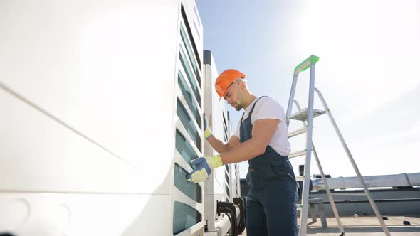 The Engineer is Making an Inspection of the Air Conditioning System alt