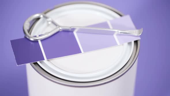 Close up of metal paint can with purple paint and paint swatch. alt