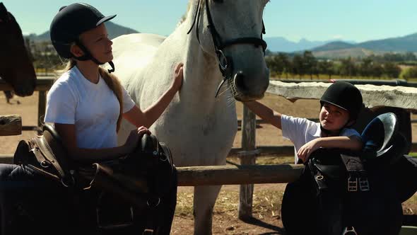 Siblings touching the white horse in the ranch 4k alt