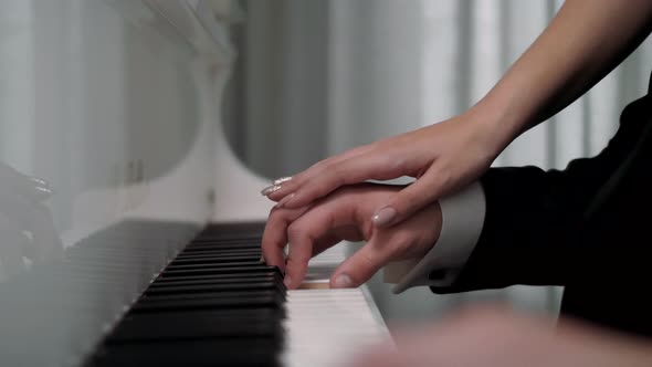 Man and girl are playing together on the piano alt