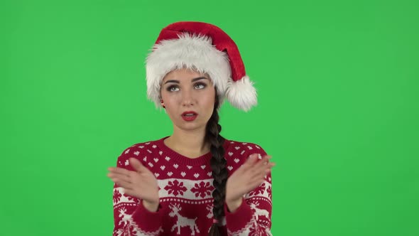 Portrait of Sweety Girl in Santa Claus Hat Is Clapping Her Hands Indifferent. Green Screen alt