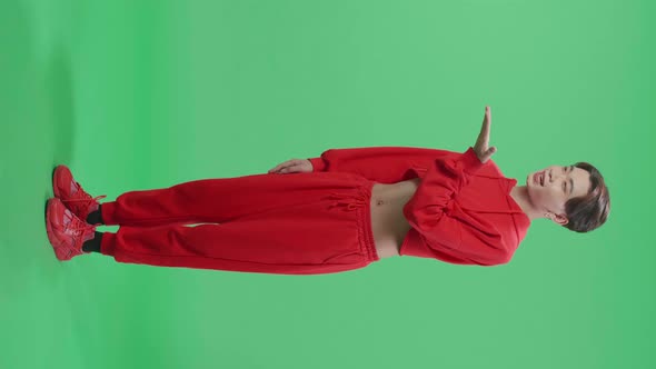 Full Body Of Smiling Asian Transgender Male Blowing Kisses To A Camera In The Green Screen Studio alt