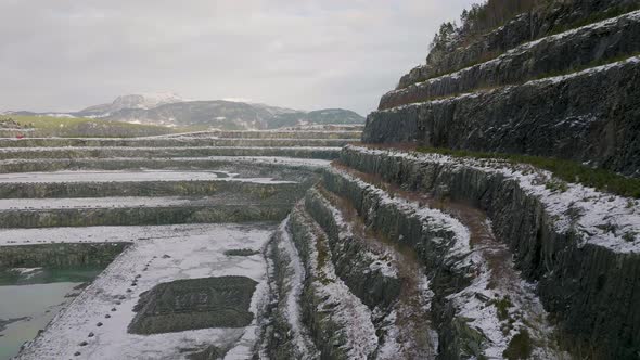 Snowy rock quarry. Rocky pit on snow landscape. Aerial of rock Mine.Bonanza work alt