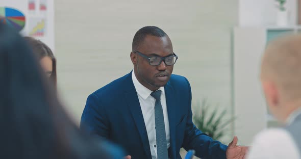 Black Businessman at a Meeting with Business Partners Tells the Strategic Plans of the Company alt
