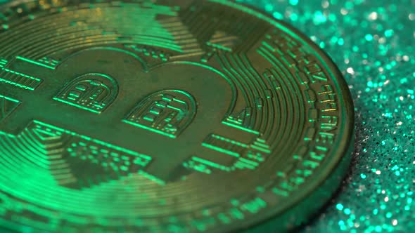 Bitcoin Coins are Illuminated By Multicolored Neon Light in Closeup alt