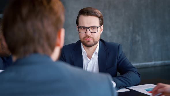 Young man in a suit working with collegues 