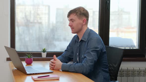 Young man communicating by conference video call speak looking at laptop at home office, video chat alt