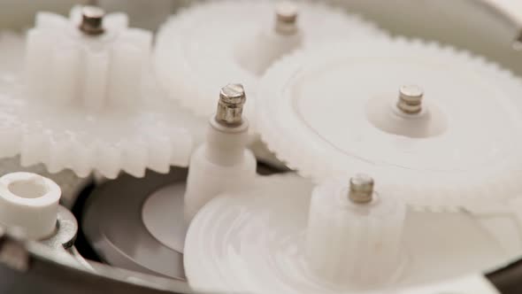 Five Plastic Gears Rotate in Mutual Mesh Inside a Small Reduction Gear alt