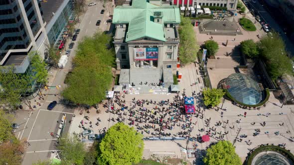 Overhead view of crowd gathered at art gallery in Vancouver. Drone shot over Robson Square in downto alt