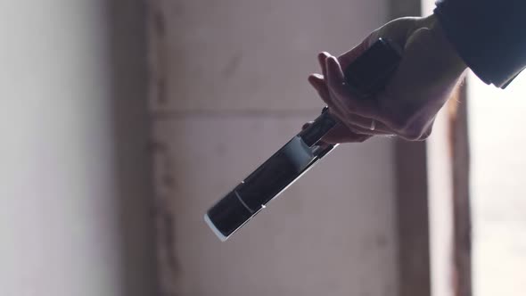 A Man Holding Steel Gun in His Hand and Rotates It alt