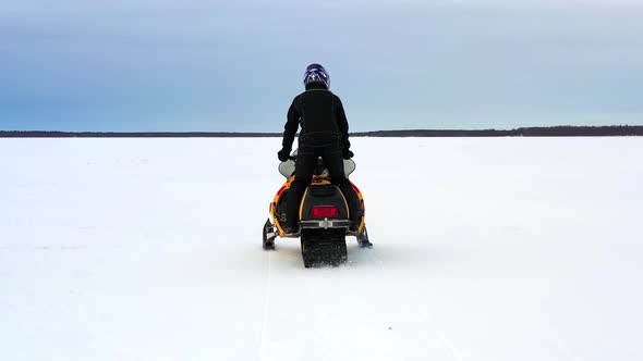 Following Snowmobile On The Ice alt