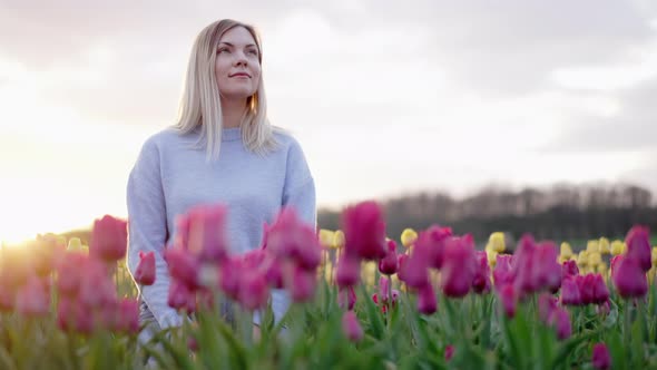 Beautiful Woman Sitting Alone in Pink Tulips Field