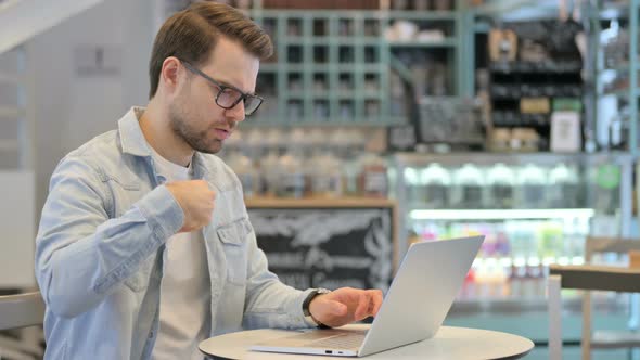 Man Having Wrist Pain While Working on Laptop alt