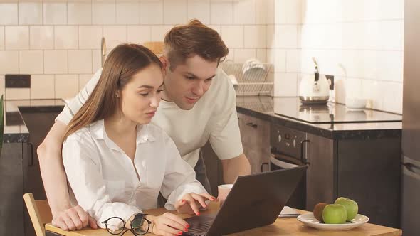 Focused Young Caucasian Couple Checking Analyzing Utilities Bills at Home