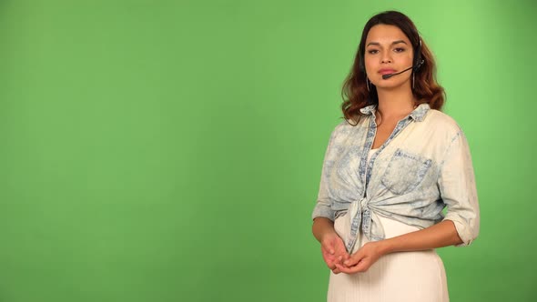 A Young Beautiful Female Technical Assistant Talks to the Camera  Green Screen Background