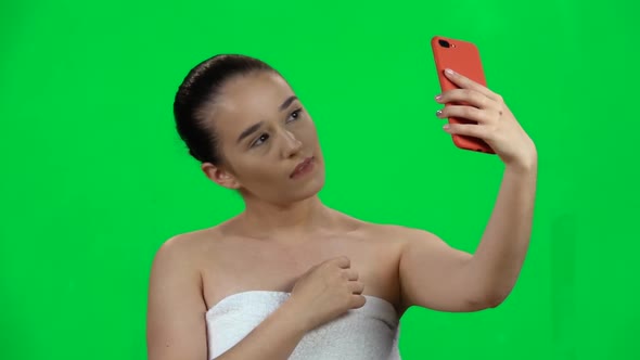 Spa Woman Sends Message on Mobile Then Makes Selfie. Green Screen. Slow Motion alt