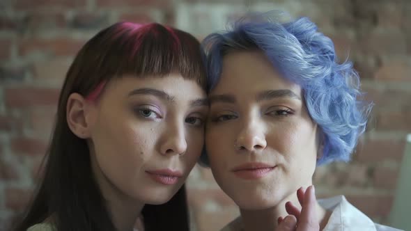 Portrait of Young Lesbian Couple Posing Together in Front of Camera at Home alt