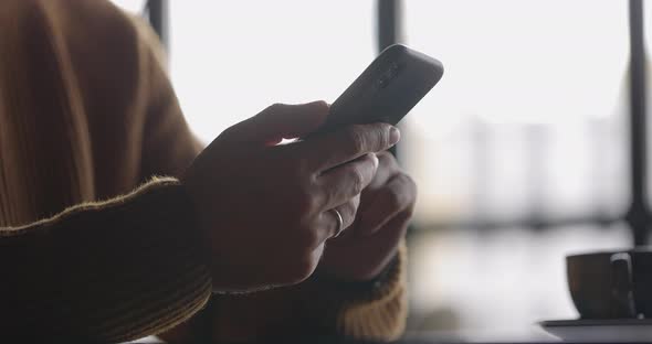 Side View of Man Hands with Watch Using Mobile Phone While Working at Laptop alt