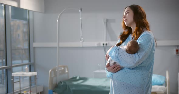 Caucasian Mother Holding Her Newborn Baby After Labor in Ward at Hospital alt
