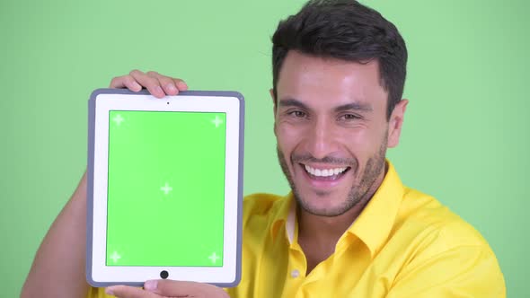Face of Happy Young Hispanic Businessman Showing Digital Tablet alt