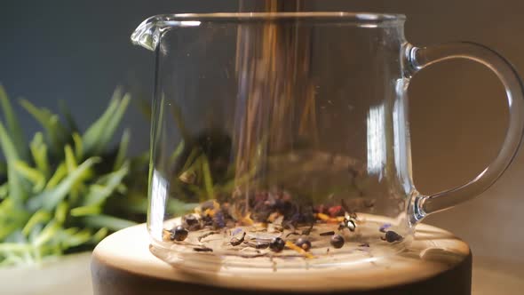 Herbal and Floral Phyto Mix of Dry Herbs is Poured Into a Glass Teapot and Poured with Boiling Water alt