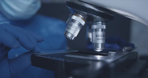 Sample Slide and Microscope with Metal Lens at Laboratory. alt