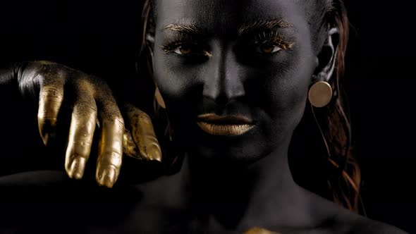 Art Portrait of a Young Female Model with Black Skin Golden Lips Hands Eyes alt
