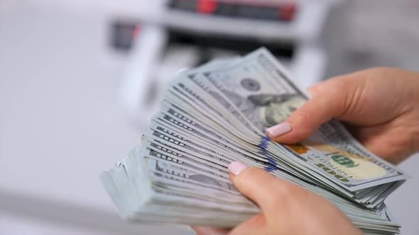 Female hands counting US Dollar bills. US national paper currency. alt